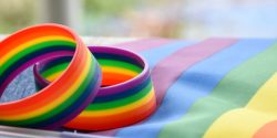 A pair of rainbow bracelets resting on a pride flag
