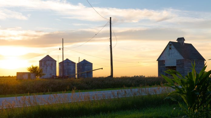 The sun sets over a rural farmland scene in Illinois