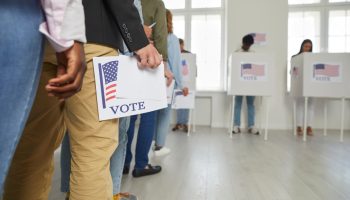 voters lining up with their ballots at a voting station