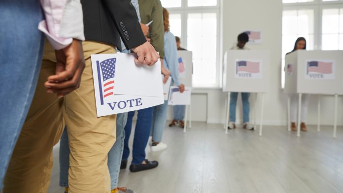 voters lining up with their ballots at a voting station