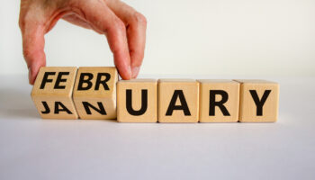 wood blocks spelling out January, switching letters to say February