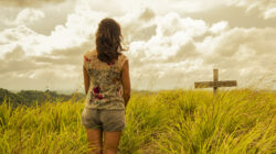 A widow looks at a grave with grief