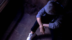 a sad woman in a grey hoodie, looking depressed