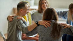 People supporting each other at an alcoholics anonymous meeting