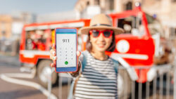 a woman holds a phone after dialing 9-1-1. Learn more about emergency and mental health crisis phone numbers in the US here.