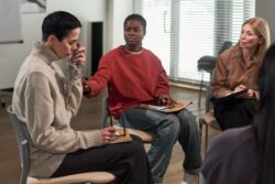 People speaking to each other at a support group meeting. Learn more about how to help someone with addiction get into treatment, here.